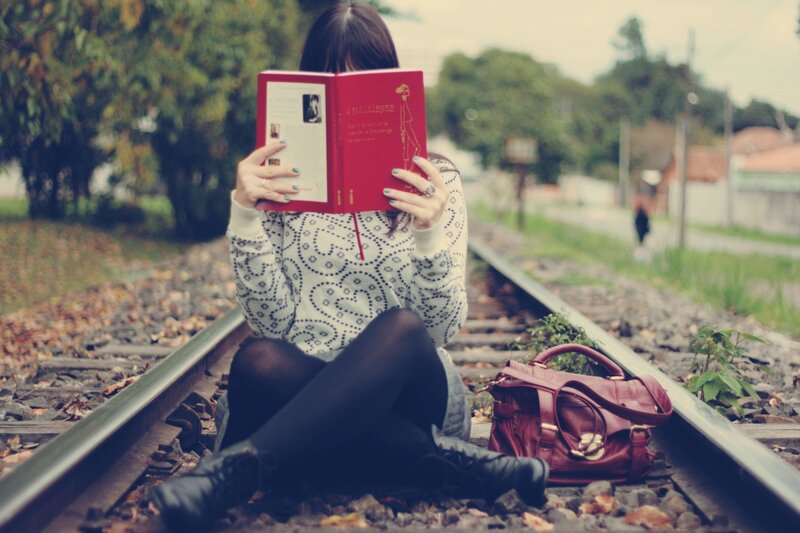 Woman reading on train tracks