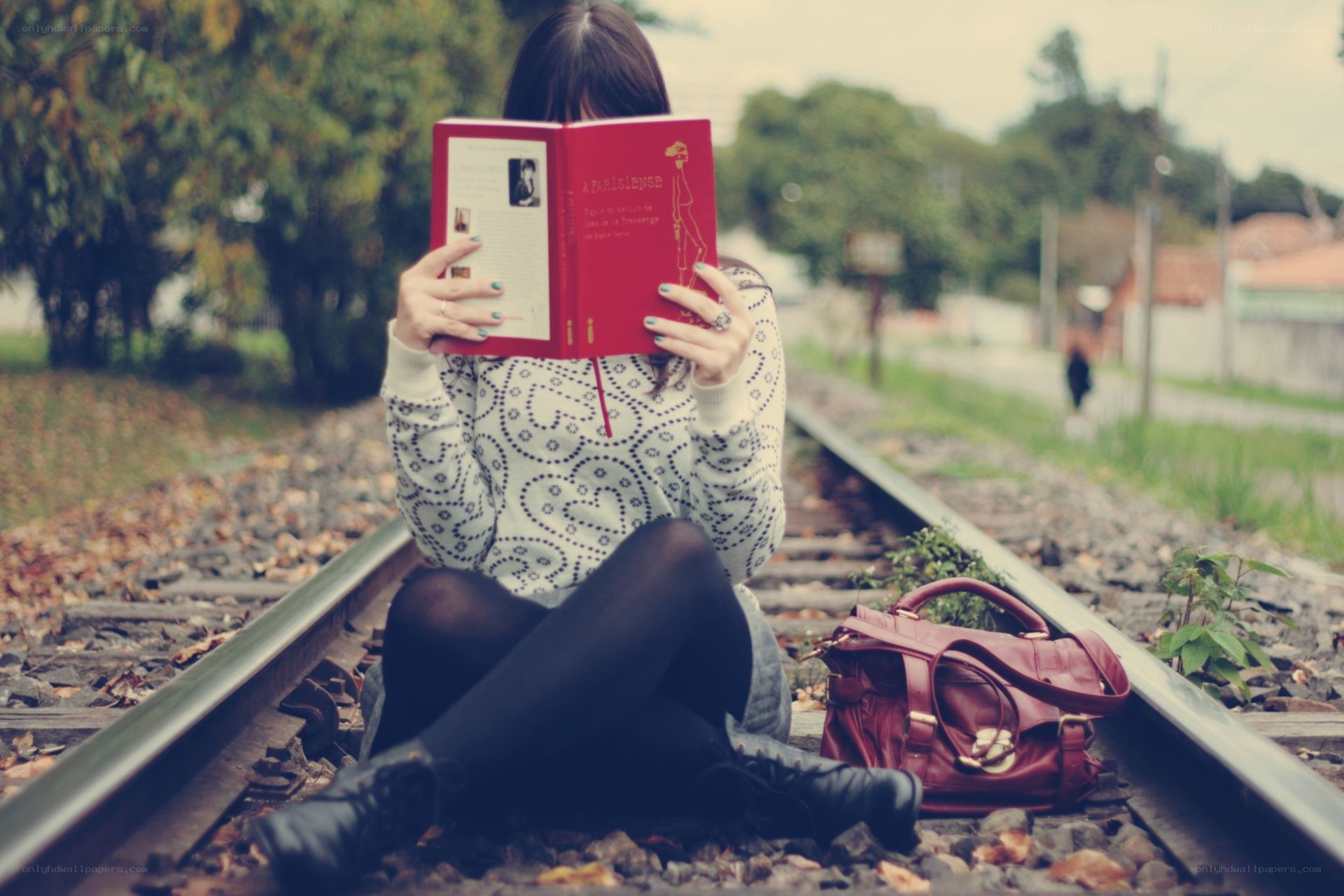 Woman reading on train tracks