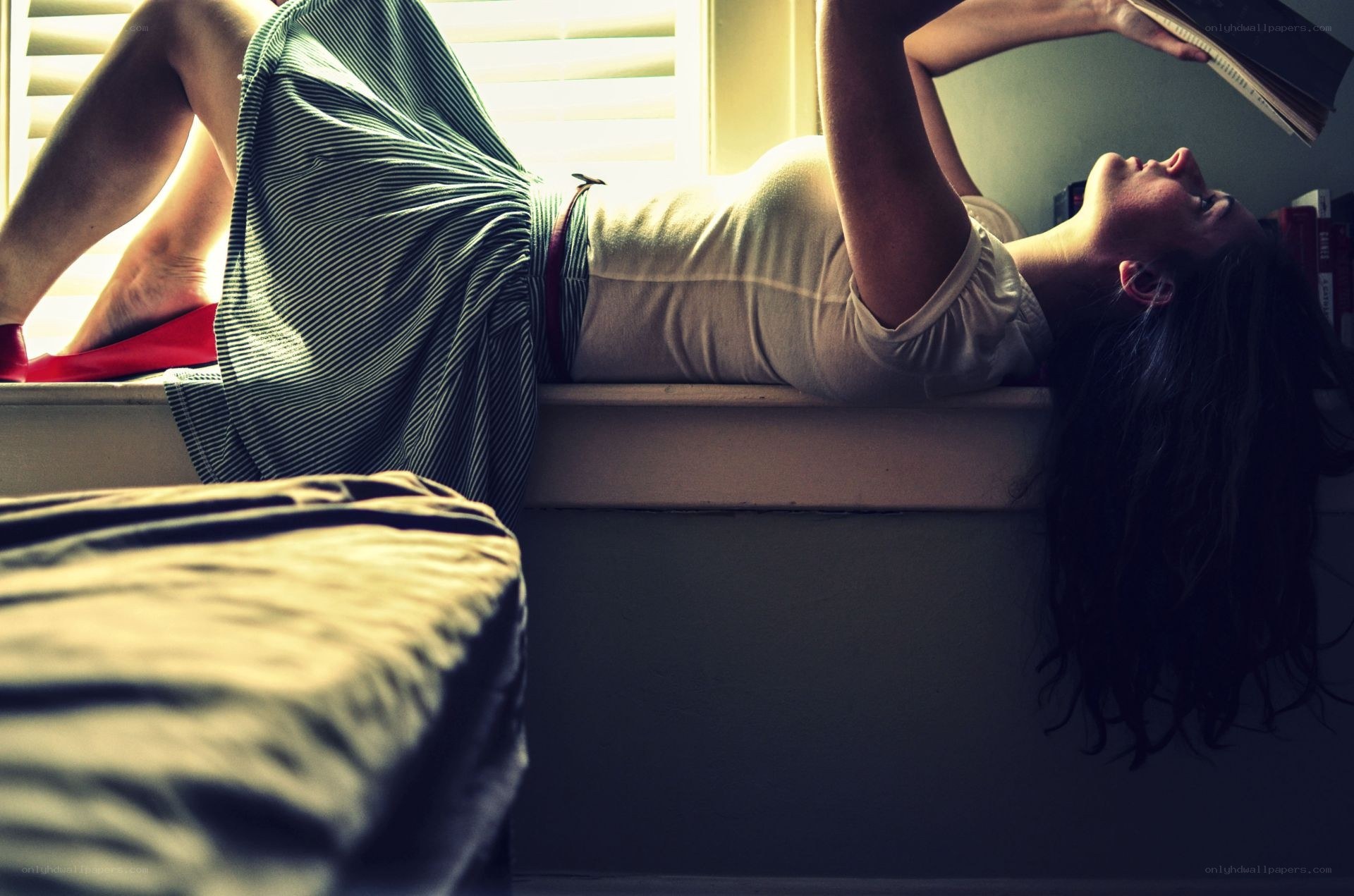 woman reading on windowsill