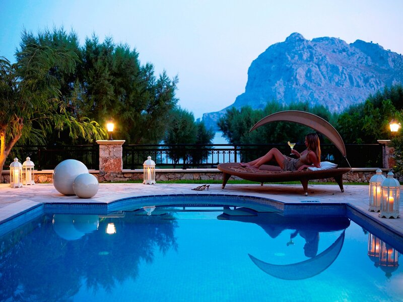 Woman relaxing by pool at dusk