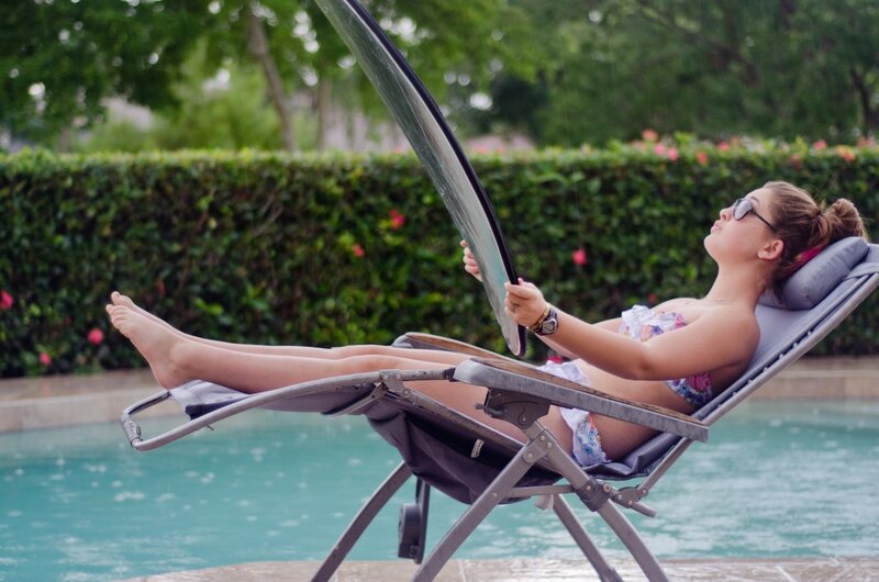 Woman relaxing by pool in rain