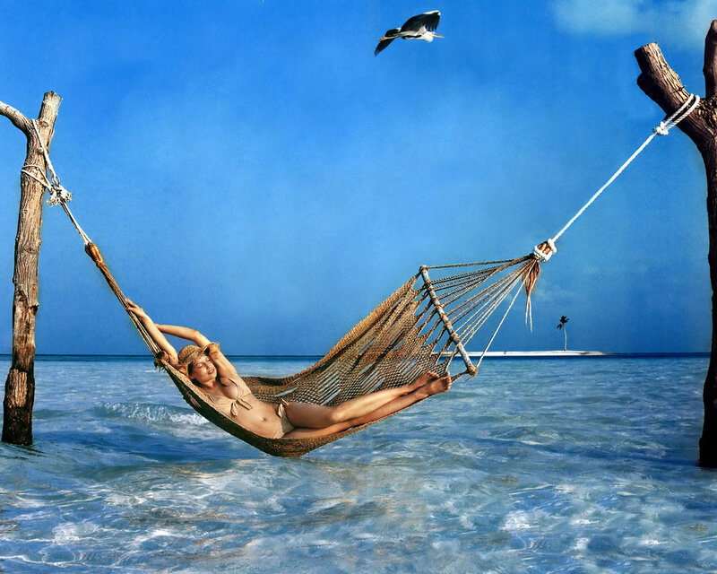 Woman relaxing in hammock on beach