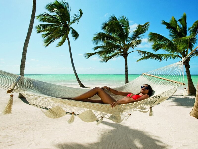 Woman relaxing in hammock on beach