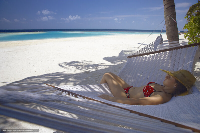 Woman relaxing in hammock on beach
