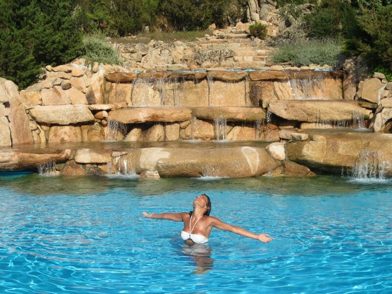 Woman relaxing in pool with waterfall