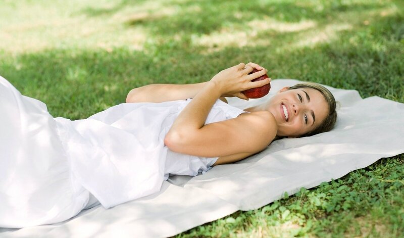 Woman relaxing on grass with apple