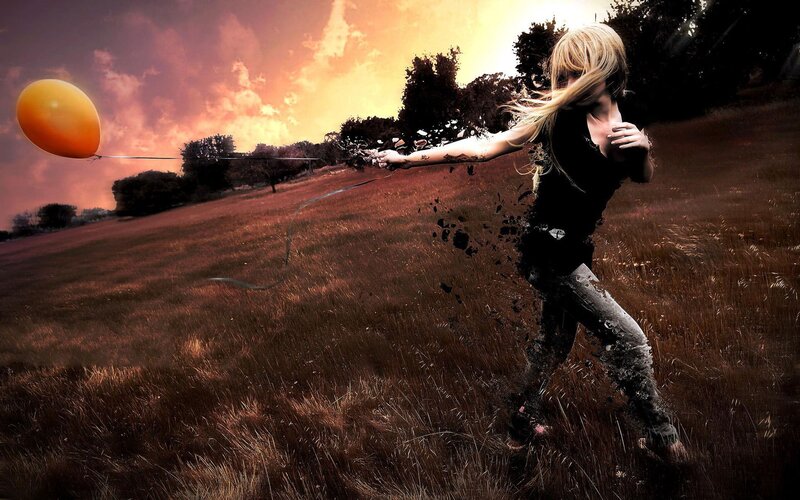 Woman releasing balloon in field