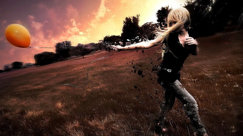 woman releasing balloon in field