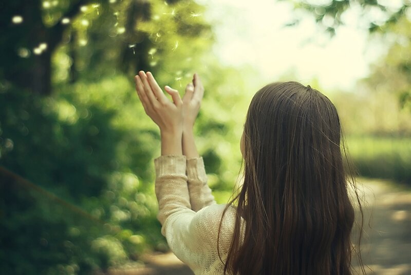 Woman Releasing Dandelion Seeds