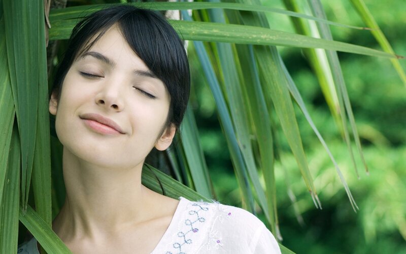 woman resting among green leaves
