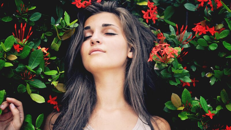 woman resting among red flowers