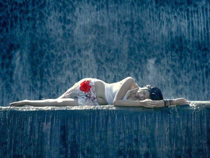 Woman resting by a waterfall