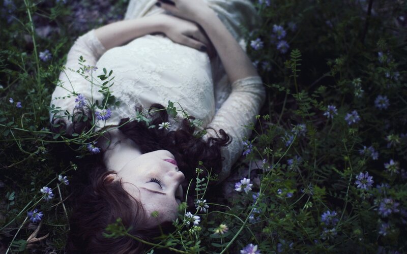 woman resting in a field of flowers