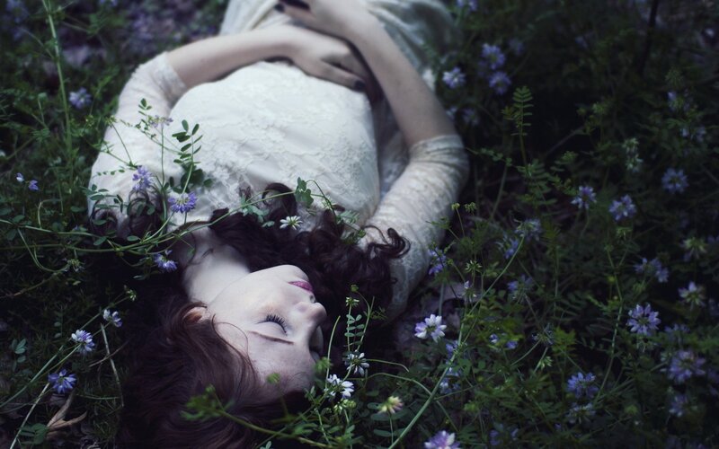 woman resting in a field of flowers