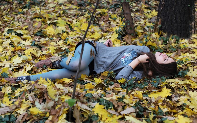 woman resting in autumn leaves