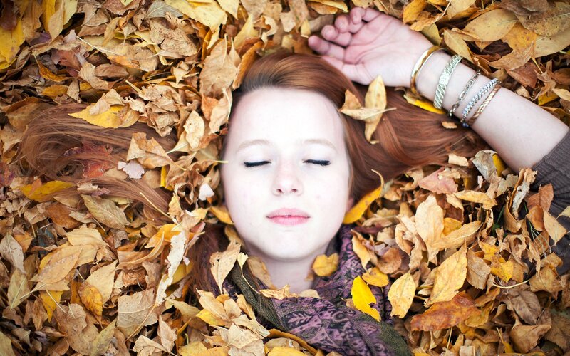 woman resting in autumn leaves