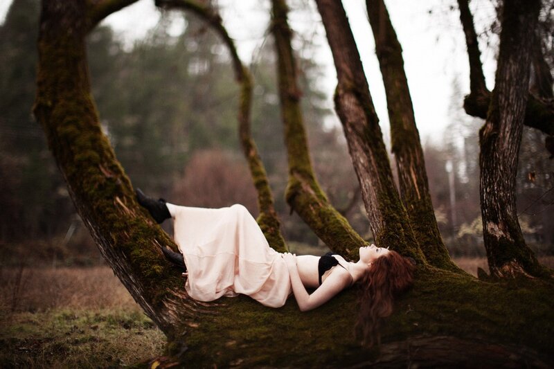 Woman resting on a mossy tree