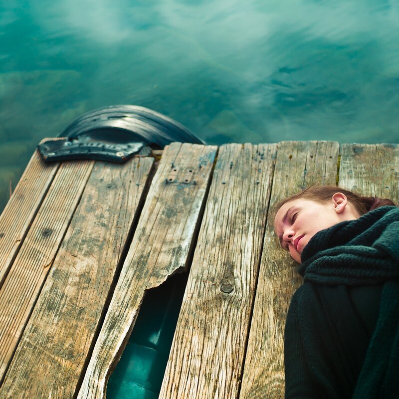 Woman resting on a wooden dock