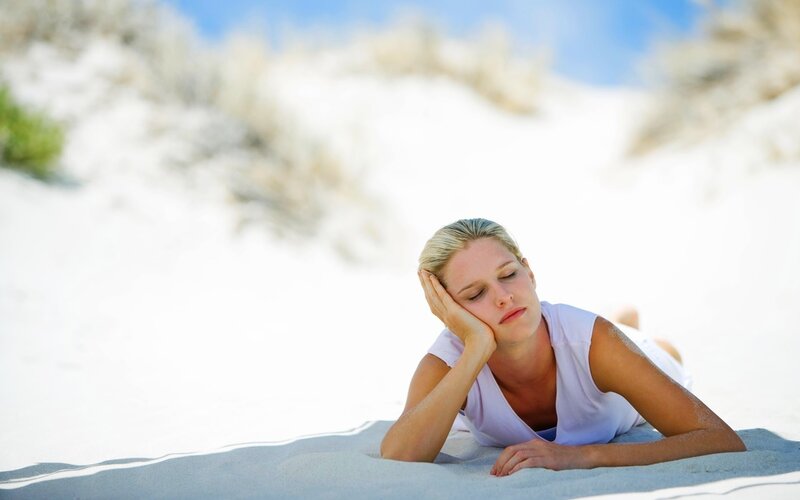 woman resting on beach sand