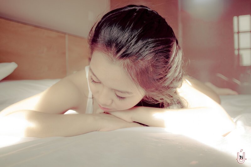 woman resting on bed in sunlight