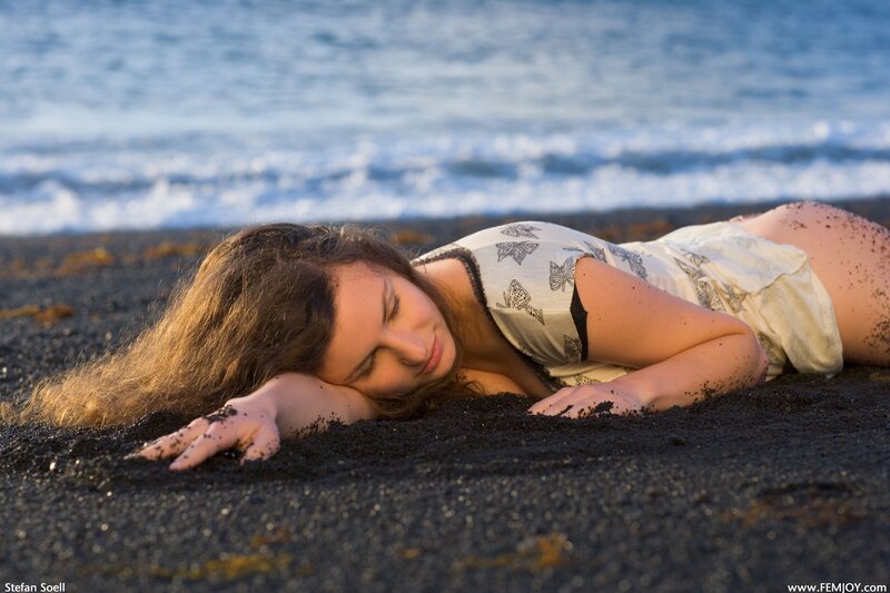 woman resting on black sand beach