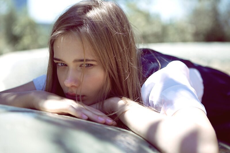 woman resting on car hood