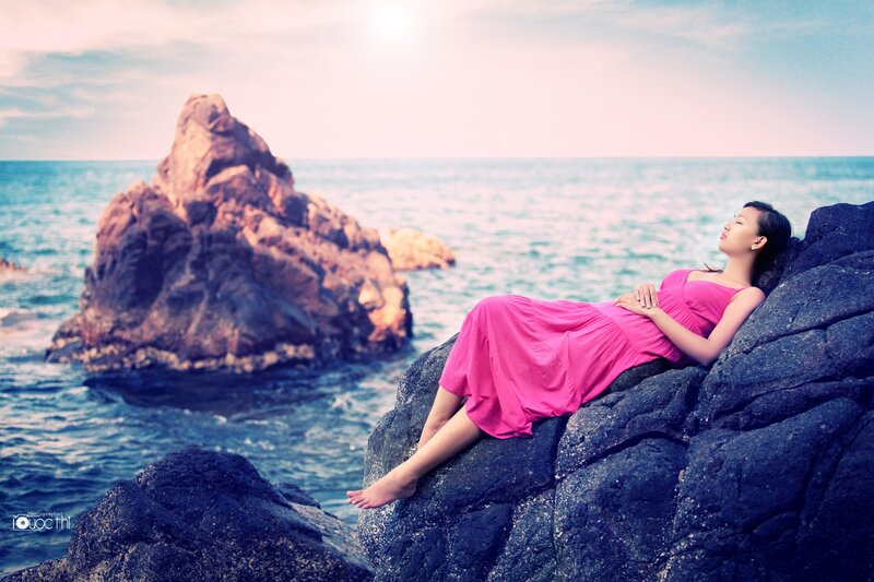 Woman resting on coastal rocks