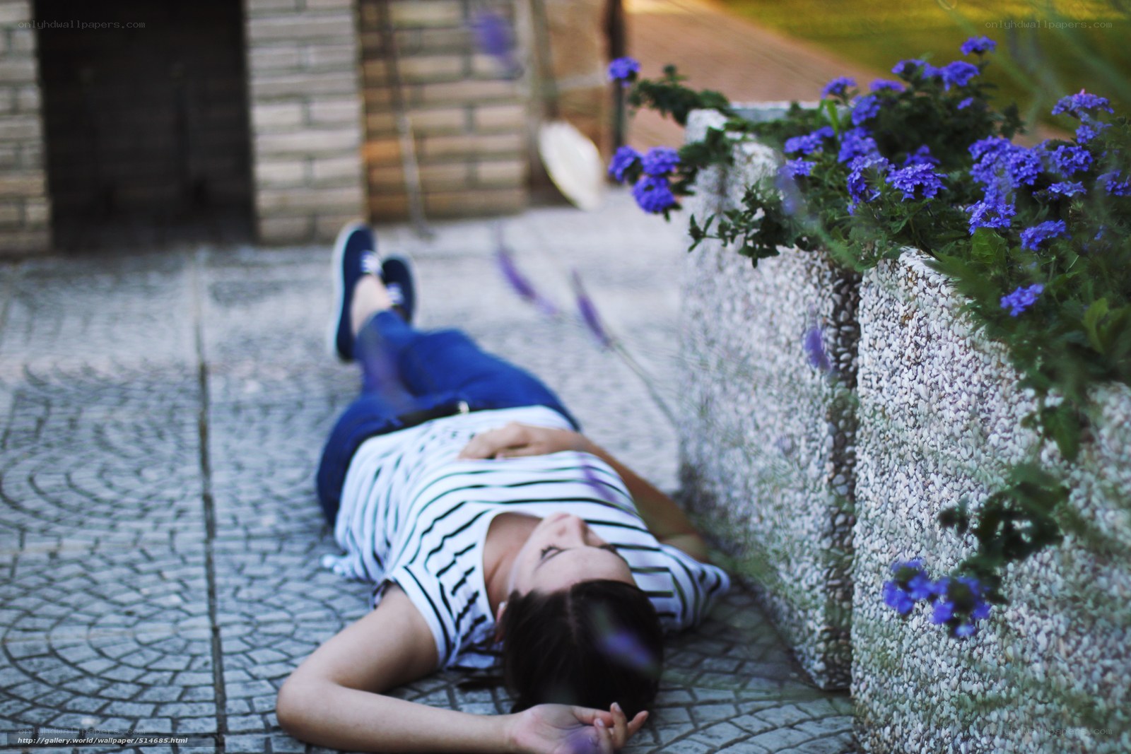 Woman resting on cobblestone path