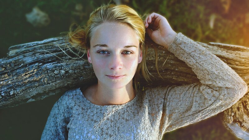 woman resting on driftwood