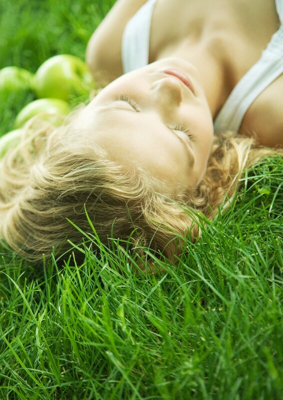 woman resting on grass with apples