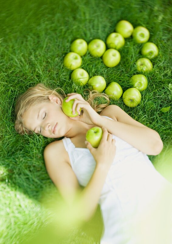 Woman resting on grass with apples