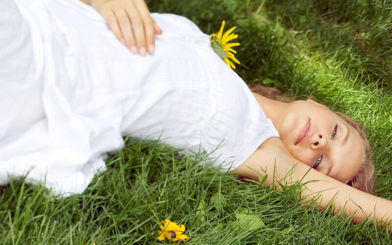Woman resting on grass with flowers