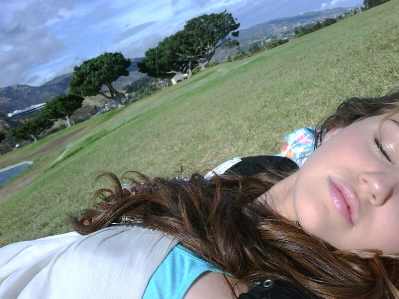 woman resting on grassy hill