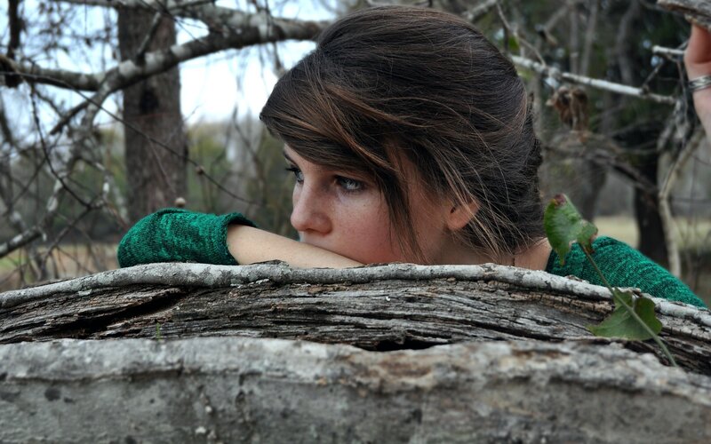 woman resting on log in forest