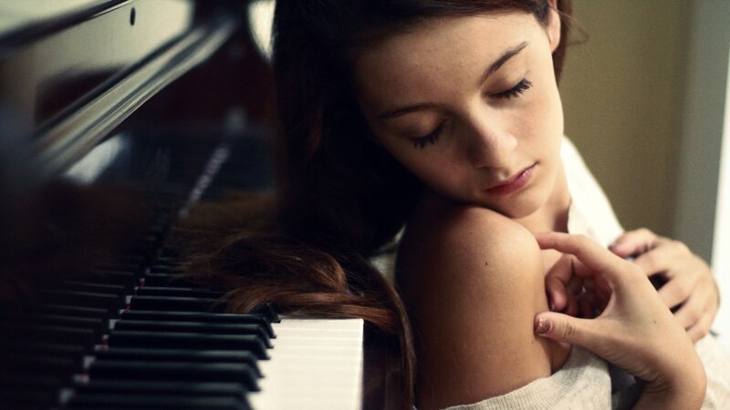 woman resting on piano