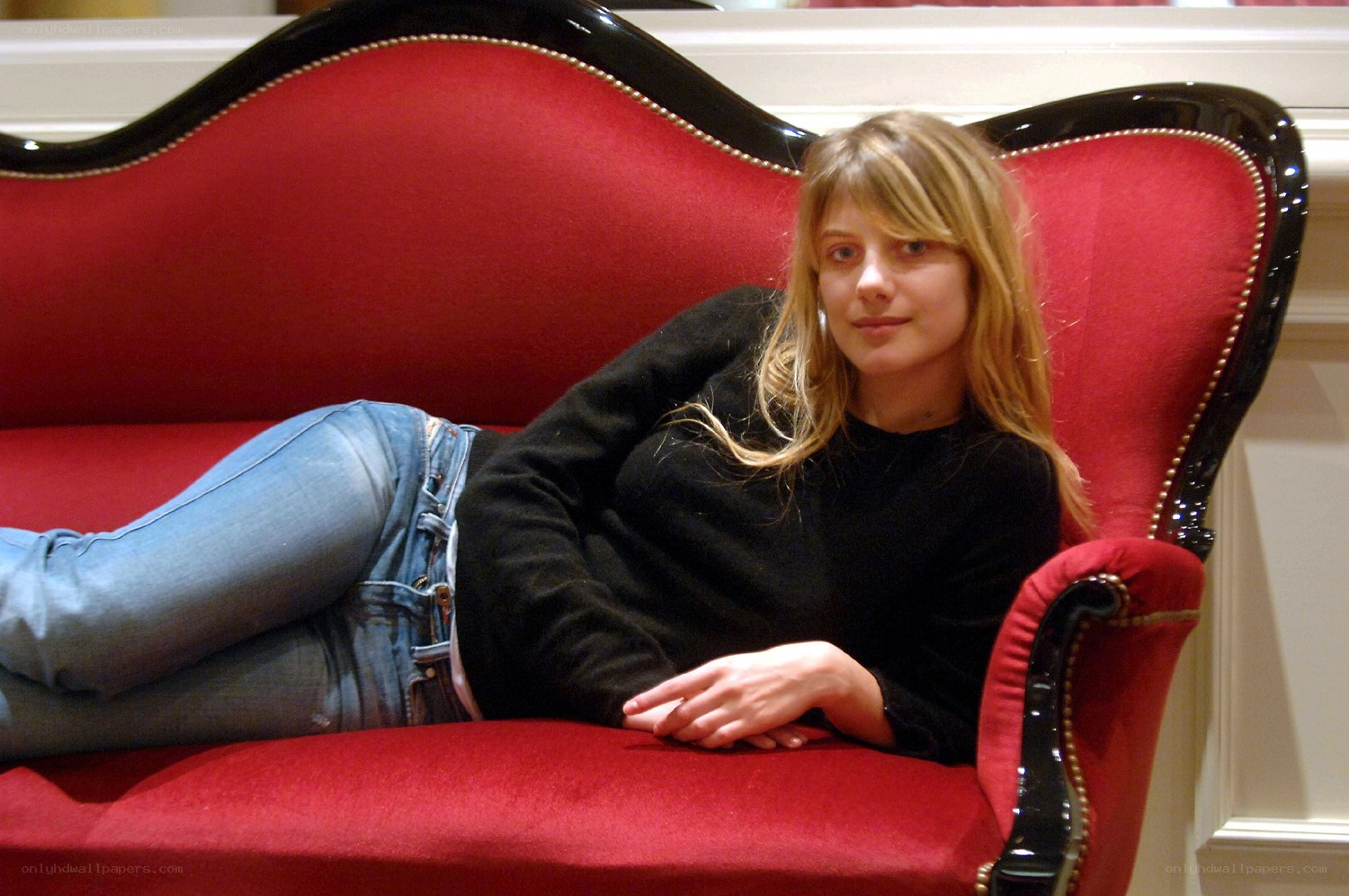 woman resting on red couch