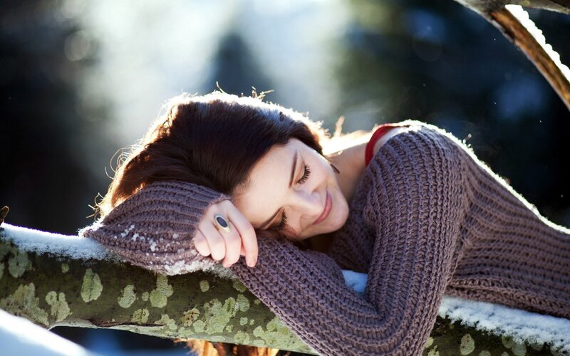 woman resting on snowy branch