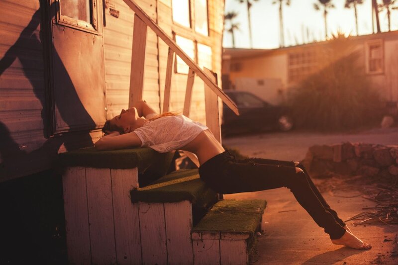 woman resting on steps at sunset