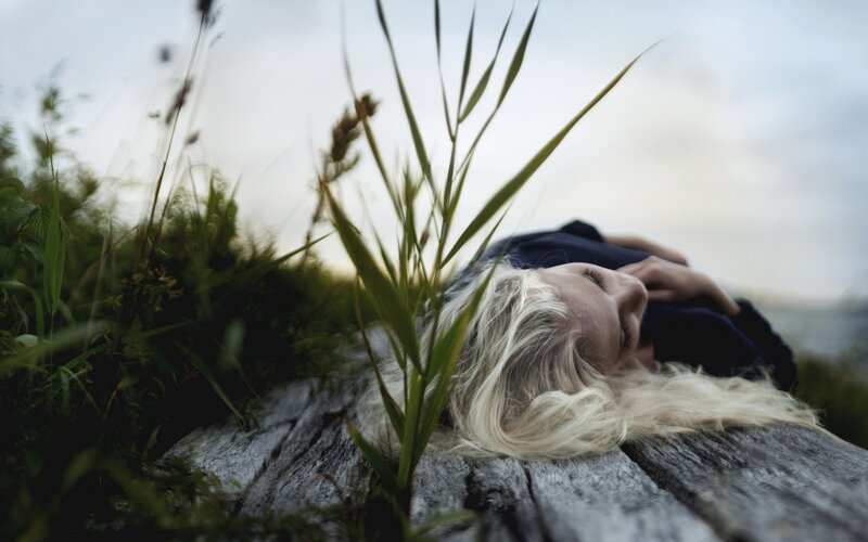 Woman resting on wooden bench