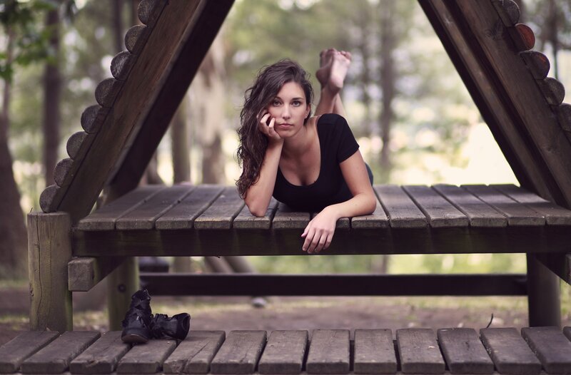 woman resting on wooden bench