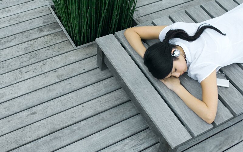 woman resting on wooden bench
