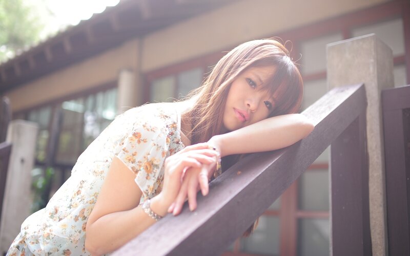 woman resting on wooden railing