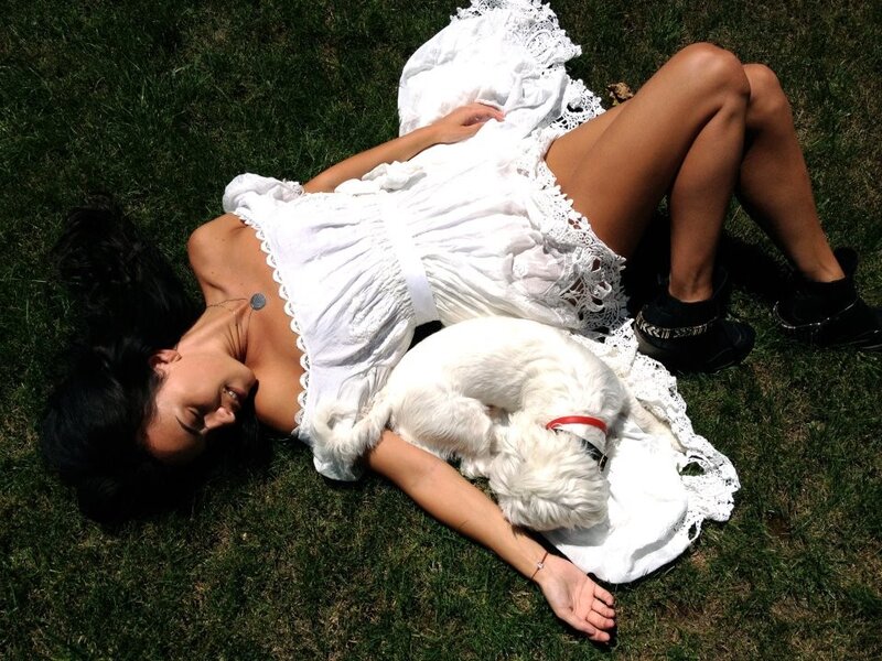 Woman resting with dog on grass