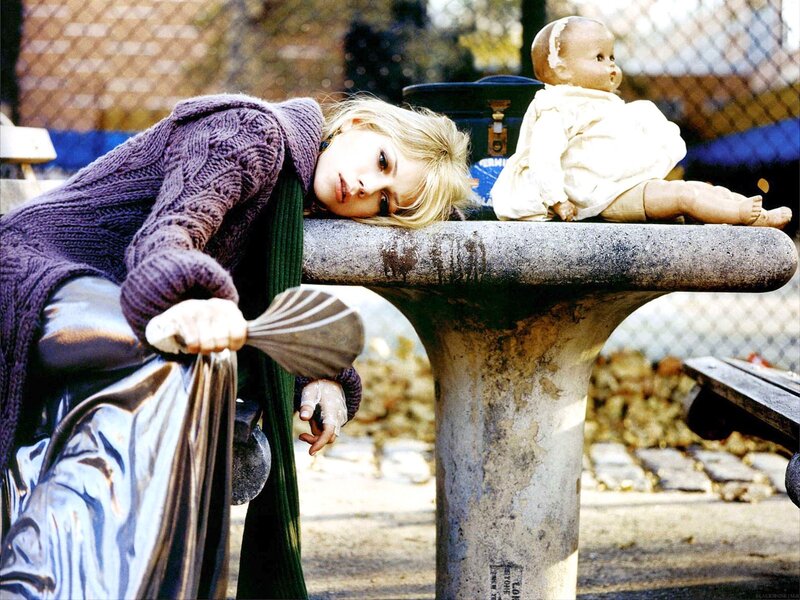 Woman resting with doll on bench