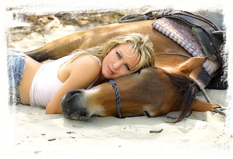 woman resting with horse on beach