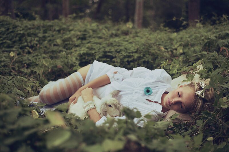 Woman resting with rabbit in forest