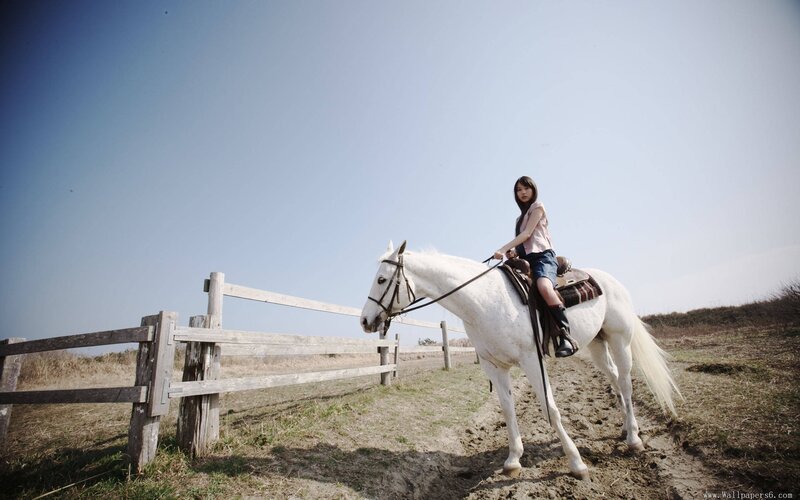Woman riding a white horse