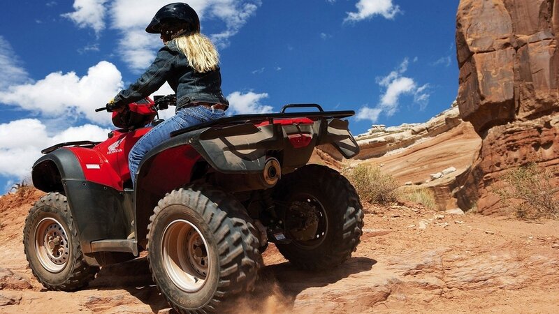 Woman riding ATV in desert