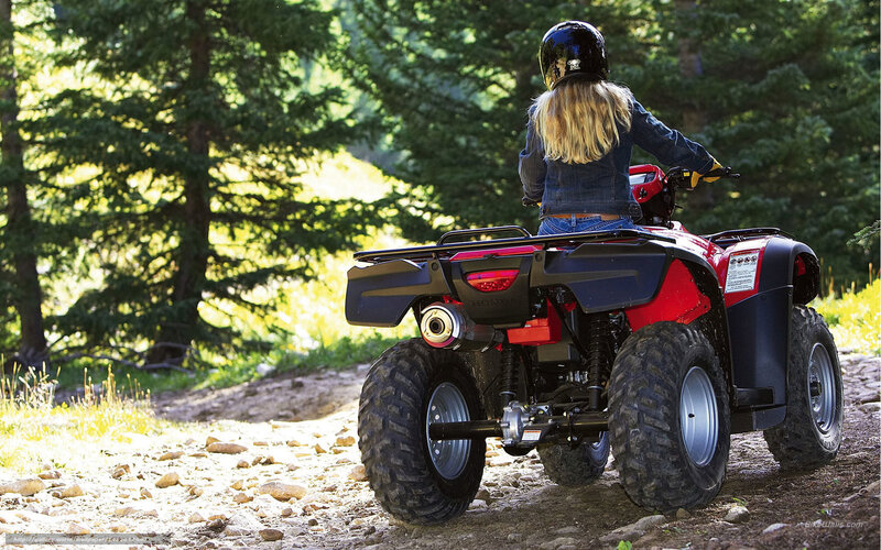 Woman riding ATV in forest
