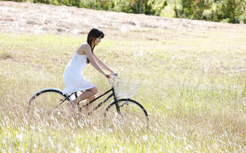 Woman riding bicycle in field